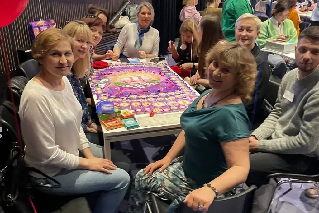 Автор игры Светлана Сухова проводит групповую сессию трансформационной игры «Вместе нельзя расстаться» для большой группы участников.